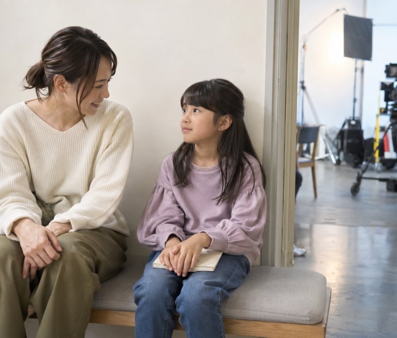 撮影スタジオの待合で静かに過ごす日本人の母親と子ども